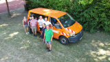 Gruppenbild vor einem orangenen Bus.
