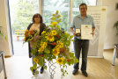 Jürgen König hält die Staatsmedaille und Urkunde. Neben ihm steht seine Frau mit Blumen.