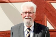 Ein etwas älterer Herr steht vor einem geschichtsträchtigen Gebäude in Kirchensittenbach. Heini Liebel hat eine Staatsmedaille für seinen langjährigen Einsatz als Ehrenamtlicher bekommen.