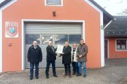 Fünf Menschen haben sich vor dem Feuerwehrhaus in Rüblanden getroffen. Sie freuen sich über die eingeleitete Dorferneuerung. 