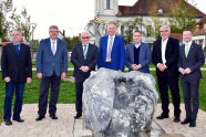 Sieben Männer stehen vor dem Abschlussdenkmal in Weidenbach. Ein Mann hat es kurz zuvor enthüllt.