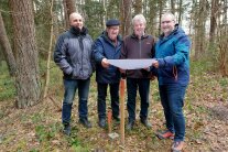 Vier Männer schauen sich nach Abschluss der Waldneuordnung in Hellenbach die Maßnahme nochmals direkt vor Ort an.