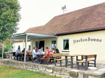 Vor der Dorfscheune in Oberalbach sitzen ein paar Männer und Frauen aus den vier kommunalen Allianzen im Landkreis Neustadt/Aisch-Bad Windsheim. Dank des Regionalbudgets bekam der Bereich eine Überdachung und die Verantwortlichen sind vor Sonne und Regen geschützt.