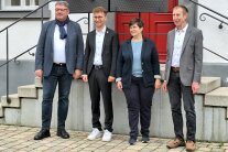 Drei Männer und eine Frau stehen vor der Treppe zum Rathaus in Ornbau. Sie sind Teilnehmer am historischen Tag in der Stadt.