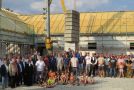 Gruppenbild: Kinder sitzen, Ehrengäste und Gäste stehen vor dem Dorfgemeinschaftshaus mit Sportheim beim Richtfest.