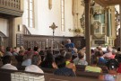 Menschen sitzen in einer Kirche und hören den Ausführungen von Dr. Wolfgang Mück zu.