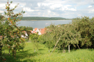 Ein fränkisches Dorf ist eingebettet in Streuobstwiesen, deren Bäume voller reifer Äpfel hängen. Dahinter liegt der Brombachsee, auf dem ein Trimaran und Segelboote fahren.