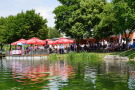 Gäste der Einweihungsfeier verweilen auf der Seeterrasse und am Ufer