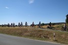 Fahrradfahrer fahren hintereinander auf einem eine Straße begleitenden Weg