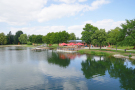 Naturbadeweiher Weißbachmühle und Terasse des Freizeitzentrums im Hintergrund. 