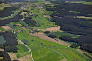 Auf dem Luftbild ist die Fränkische Rezat zu sehen, wie sie sich durch Wiesen und Felder schlängelt. Dörfer, Straßen, Wege und Wälder liegen links und rechts von ihr.