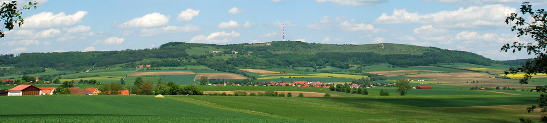 Es sind Dörfer eingebunden in die fränkische Landschaft zu sehen. Im Hintergrund liegt der Hesselberg, die höchste Erhebung Mittelfrankens.