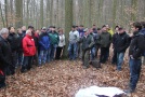 Rund 35 Waldbesitzer stehen im Halbkreis und folgen den Ausführungen eines Spezialisten für Waldneuordnung.