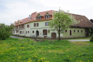 L-förmige Gebäudeanordnung. Das ehemalige Gasthaus wurde für Sozialwohnungen saniert. Der andere Teil steht leer und noch zur Sanierung für gemeinschaftliche Zwecke an.